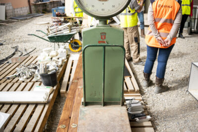 Une balance posée sur des palettes en bois, sur un chantier, à côté de personnes en gilets et casques de chantier - Agrandir l'image 9 sur 9, fenêtre modale